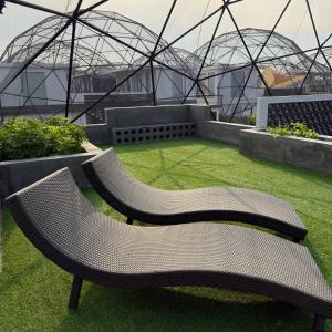 two benches sitting on the grass in front of a building at Huahin House Premium in Hua Hin