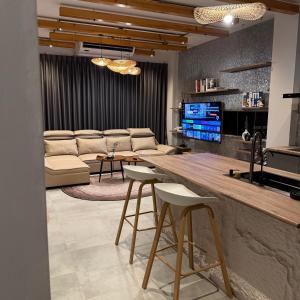 a living room with a couch and a bar with stools at Huahin House Premium in Hua Hin