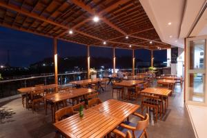 a restaurant with wooden tables and chairs on a roof at Zasgo Hotel in Labuan Bajo