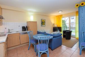 eine Küche mit einem blauen Sofa und einem Tisch und Stühlen in der Unterkunft Birkenstraße 7 Whg 2 in Zingst