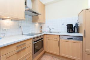 eine Küche mit Holzschränken und einer Spüle in der Unterkunft Birkenstraße 7 Whg 2 in Zingst