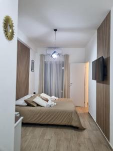 une chambre avec un grand lit et une télévision dans l'établissement Niluna, à Naples 99 autres photos