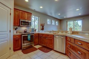 a large kitchen with wooden cabinets and stainless steel appliances at Quinn Creek in Bend