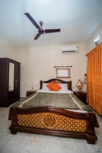 a bedroom with a large bed with a ceiling fan at Vacation homestay Goa in Aguada