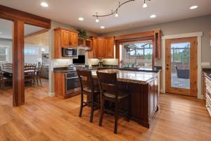 a kitchen with wooden cabinets and a island with bar stools at Five Peaks in Bend