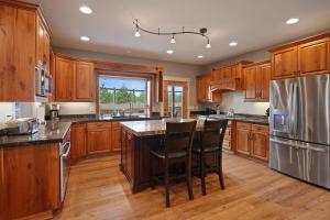 a kitchen with wooden cabinets and stainless steel appliances at Five Peaks in Bend +41 photos