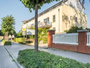 a building with a tree next to a sidewalk at Ostseeresidenz - Whg 17 in Groß Kirr