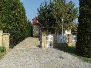 a house with a white fence and a driveway at Ferienhaus Nr 2B in Balatonszárszó