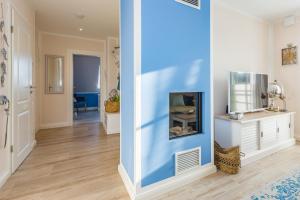 a hallway with a blue wall and a fish tank at Lütten Kate 03 in Zingst