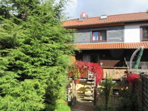 una casa con una valla y un árbol con flores rojas en Ferienhaus Schulze en Schierke