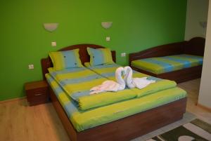 ein Schlafzimmer mit zwei Betten mit Schwänen darauf in der Unterkunft Guest House H Dzhogolanov in Kopriwschtiza + 72 Fotos