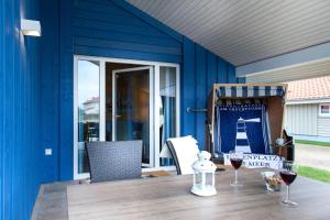 a table with wine glasses on a blue wall at Typ A plus "Schoner" -Skipperhaus- in Pelzerhaken