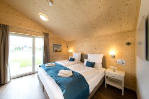 a bedroom with a large bed and a large window at Typ A plus "Schoner" -Skipperhaus- in Pelzerhaken