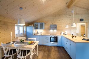 a kitchen with blue cabinets and a wooden ceiling at Typ A plus "Schoner" -Skipperhaus- in Pelzerhaken