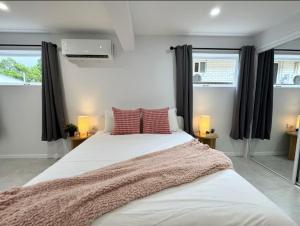 a bedroom with a large white bed with red pillows at 17B Willow Studio in Sunnybank in Brisbane