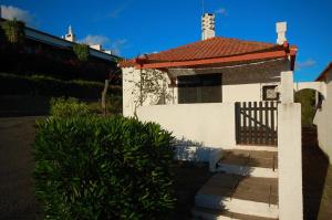 een wit huis met een rood dak en een poort bij Pedras D'el Rei Villa V1 in Tavira