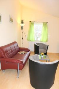 a living room with a leather couch and a table at "Hof Triangel - Whg 1" - Bauernhofurlaub in Riepsdorf