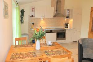 a kitchen with a wooden table with a vase of flowers at "Hof Triangel - Whg 1" - Bauernhofurlaub in Riepsdorf