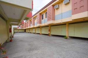 an empty courtyard of a building with pink and blue at Silks Inn in Malabañas