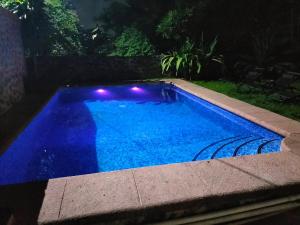 ヒウテペックにあるfinca Max amates 1の夜間の青いスイミングプール(照明付)