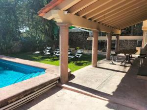 eine Pergola über einem Swimmingpool im Garten in der Unterkunft finca Max amates 1 in Jiutepec