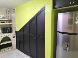 eine Küche mit schwarzen Schränken und einem Kühlschrank in der Unterkunft finca Max amates 1 in Jiutepec + 26 Fotos