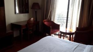 亚的斯亚贝巴FT Hotel的一间带床、书桌和窗户的酒店房间