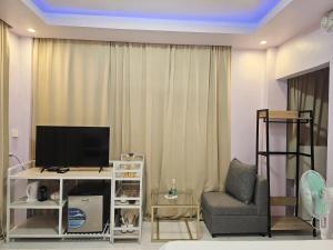 a living room with a tv and a chair at Lio Palm Villas in Langi-langiban