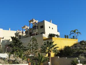 a building on top of a hill with palm trees at Villa Marina Aguilas Apt. BC1 in Águilas