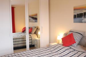 a bedroom with two beds and a mirror at Ostseeresidenz - Whg 24 in Groß Kirr +10 photos