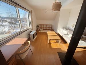 a living room with a large window and a couch at Hotel風土 in Taiki