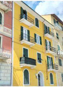 a yellow building with windows and balconies at Calipso casa vacanza in La Spezia