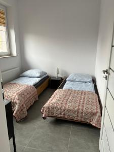 two beds in a small room with two beds sidx sidx sidx at City Center Szczytno I in Szczytno