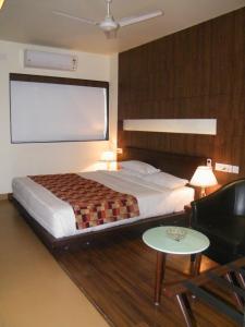 a bedroom with a bed and a large screen at Hotel Skylark in Dhanbād