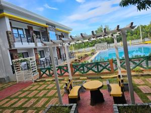 a patio with a table and benches next to a pool at Summerville Hotel and Resort in Palayan City