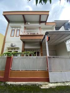 a house with a white fence in front of it at Ata Homestay Purwokerto in Purwokerto