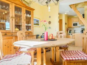Una cocina con una mesa y sillas de madera. en lütt Matten, en Prerow