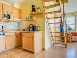 Una cocina con una escalera que sube a la parte superior de la cocina. en lütt Matten, en Prerow