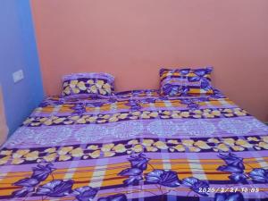 a bed with a colorful comforter and pillows at Swastik HomeStay in Ayodhya