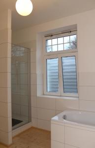 a bathroom with a bath tub and a window at Haus Roy Ferienwohnung 1Etage in Zülpich