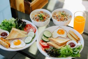 a table with two plates of breakfast foods and bowls of food at ภูสิริ โฮมสเตย์ in Ban Thung Phan Ha