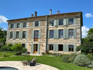 an old stone building with a bench in front of it at Domaine de Bernou in La Croix-Blanche