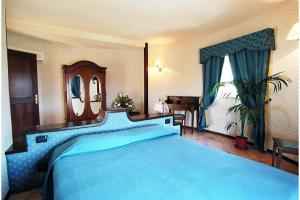una camera da letto con un letto blu e uno specchio di Hotel Tre Torri a Villaggio Mosè