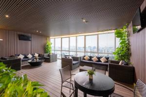 a room with couches and a table and chairs at Lancaster Hanoi City Center Apartments in Hanoi