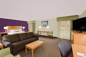 a hotel room with a couch and a bed at Ramada by Wyndham Marquette in Marquette