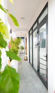 a hallway with glass doors and potted plants at Natural Light STU 402 Near Uncle Ho's Mausoleum in Hanoi +6 photos
