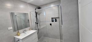 a bathroom with a shower and a toilet and a sink at New 5x bedroom The Ponds House in Schofields +16 photos