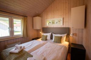 a bedroom with a large bed in a wooden wall at Typ H "Lord Nelson" -Sundhaus- in Pelzerhaken