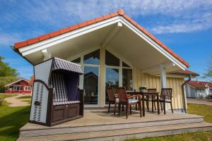 a house with a table and chairs on a deck at Typ H "Lord Nelson" -Sundhaus- in Pelzerhaken +15 photos