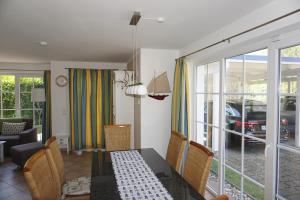 a dining room with a dining table and a living room at Kranich in Zingst